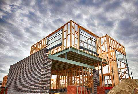 Home in early stage of being built with wooden frame and bricks