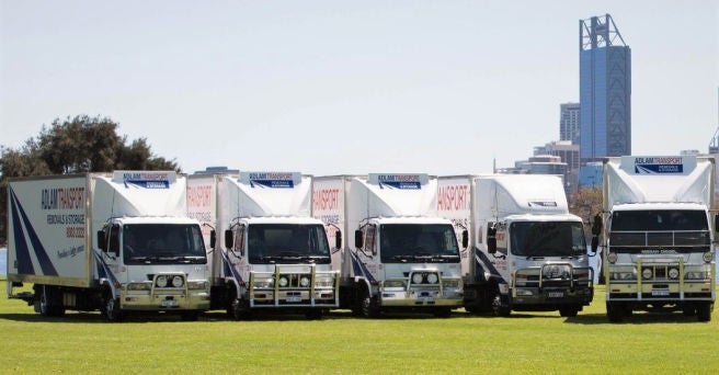 Five Adlam removalist trucks in a line