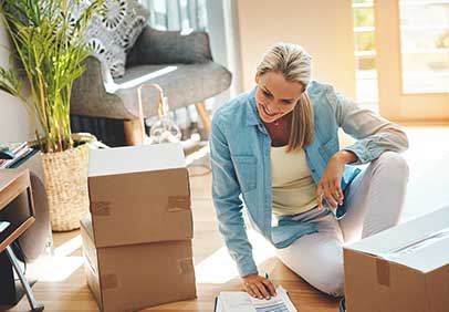 Woman sitting on floor with boxes and smiling